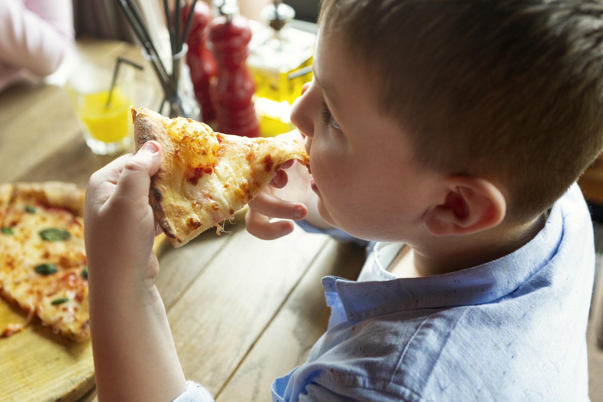primo-piano-ragazzo-con-fetta-di-pizza